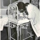 Photo:Nurse and doctor examining an infant, 1970 (catalogue reference: SBHF/PG/28)